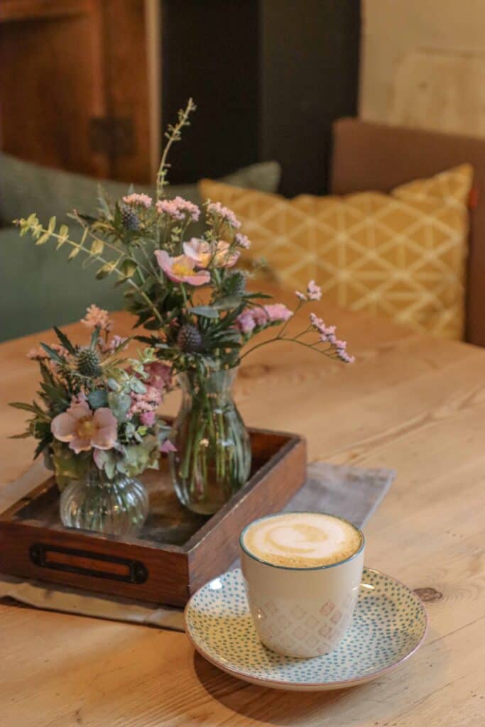 Blumensträußchen auf einem Tisch zusammen mit einem leckeren Cappuccino